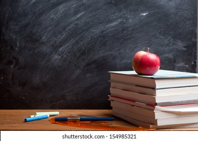 red apple resting on the book with chalk board as background - Powered by Shutterstock