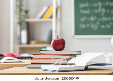 Red apple with school books and eyeglasses on table in classroom - Powered by Shutterstock