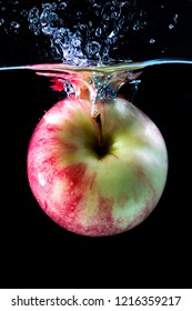 Red Apple Spash In Water On Black Background