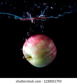 Red Apple Spash In Water On Black Background