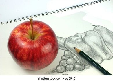 Red apple and still life fruit sketch in background and pencil