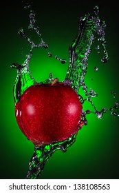 Red Apple With Water Splash On Green Background