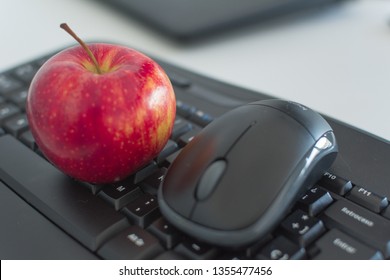 Red apple  and wireless mouse over a black keyboard as a representation of balance between healthy habits  and proffessional life. - Powered by Shutterstock