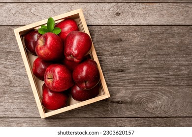 Red apple in wooden box (crate) isolated on wooden table background with copy space, top view, flat lay. - Powered by Shutterstock