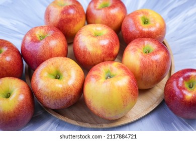 Red Apple In Wooden Plate On Wooden Background, US. Red Envy Apple On Wooden Table.