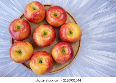 Red Apple In Wooden Plate On Wooden Background, US. Red Envy Apple On Wooden Table.