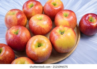 Red Apple In Wooden Plate On Wooden Background, US. Red Envy Apple On Wooden Table.