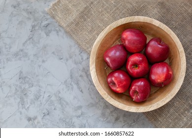 Red apples background. Ripe red apples in wooden box. Top view with space for your text. Apples In Wooden plate On gray concrete table. Organic food and healthy food concept. raw food diet, fruits, 