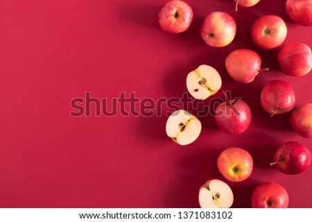 Red apples on a red background. Flat lay, top view, copy space