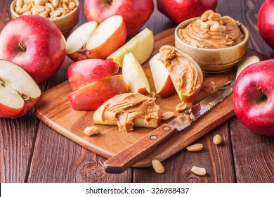 Red apples and peanut butter for snack, selective focus.