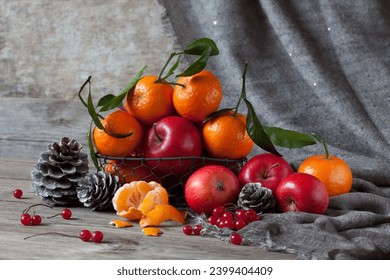 Red apples, tangerines, berries and pine cones on a wooden table. Beautiful Christmas still life, postcard - Powered by Shutterstock