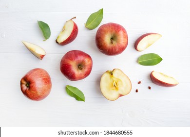 Red apples, whole and pieces with leaves on a white background. Poster.