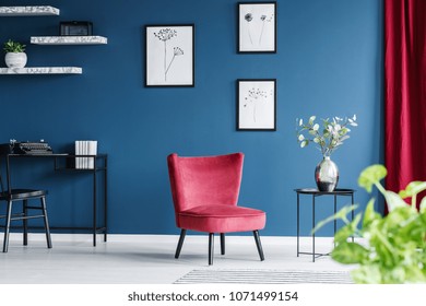 Red Armchair In Blue Living Room Interior With Workspace With Black Chair At Desk