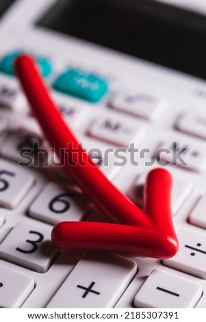 Red arrow on white calculator symbolizing economic decline stock market economy recession downfall crash