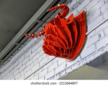 A red artificial bull's head hanging on a white brick wall - Shutterstock ID 2213684897