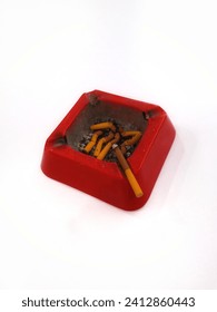 A red ashtray with seven cigarettes on a white background