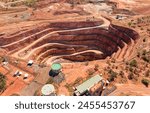 Red Australian OUtback soil in Cobar town with open pit copper mine - aerial top down view.