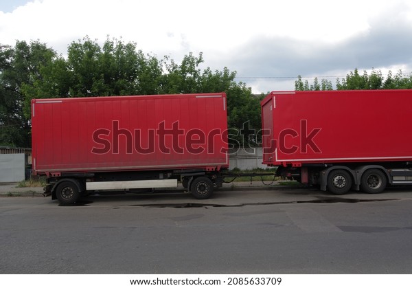 Red auto trailers. Food delivery in red\
containers. Delivery of goods by\
trucks.