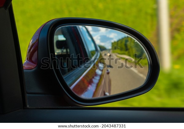 Red automobile mirror, the road is
reflected in the long-distance mirror of the
car