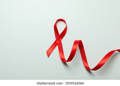 Red awareness ribbon on white background, space for text