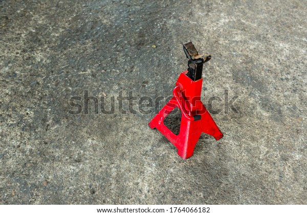 Red axle stand on floor. Red high lift jack
stand on the floor. Red extendable jack stands are used to lift up
and support.