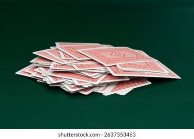 Red back playing cards deck spread on green table