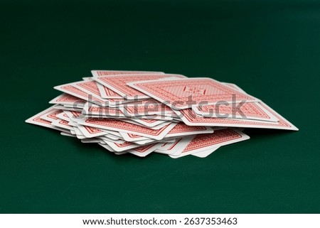Red back playing cards deck spread on green table