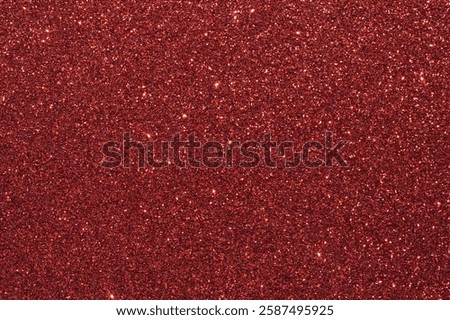 A red background with a lot of glittery red dots. The background is a deep red color, and the dots are small and shiny, creating a sparkling effect. The image has a lot of texture and depth