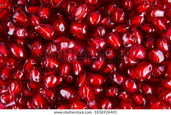 Red Background of Grain Red Grenades. Big Ripe Red\
Granets or Garnets. Fruits of Red Ripe Pomegranate on the White\
Background. Vegetarian Concept, Organic Vitamins. Organic and\
Benefit Garnet Fruit.