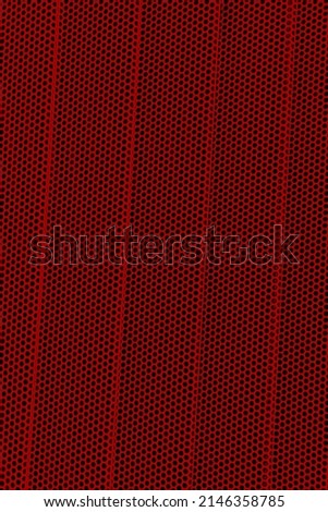 Red background of wavy metallic grid with holes. Metal mesh as background. Perforated metal back. 
