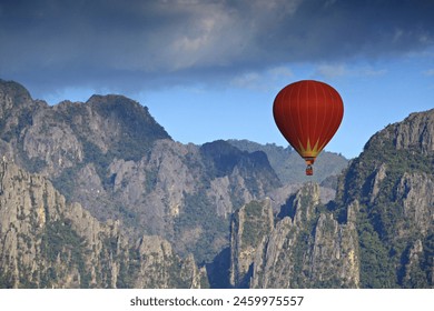 A red balloon floats on blue sky and mountain background in Vang Vieng, Laos - Powered by Shutterstock
