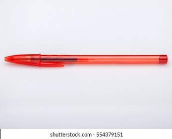 Red ballpoint gel pen on white background, capped