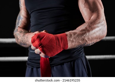 Red bandages on the hands of a kickboxer against the background of the ropes of the ring. The concept of mixed martial arts. MMA - Powered by Shutterstock