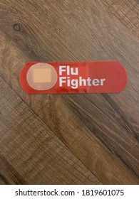 Red Bandaid With Message Flu Fighter On Wood Background