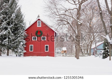 Red barn with Christmas wreath on snowy midwestern day
