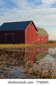 Red barn in a flooded field with reflection