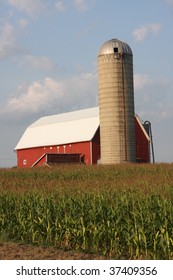 Red Barn With Silo And A Field Of Corn