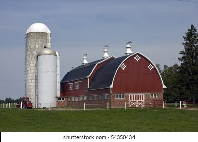 Red Barn With Silos And Tractor On A Dairy Farm