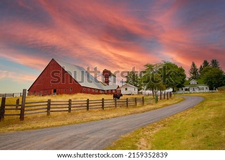 A red barn at sunrise in the fall season in the palouse wheat country in southeastern Washington.
