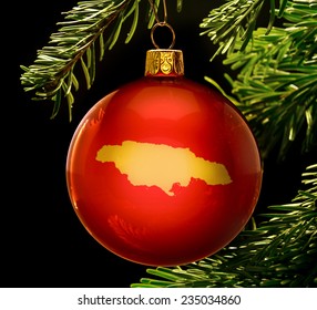 A red bauble with the golden shape of  Jamaica hanging on a christmas tree isolated on black.(series)