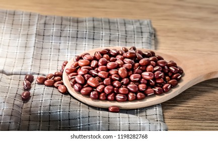 Red bean cereal in spoon,put on cloth and wooden floor