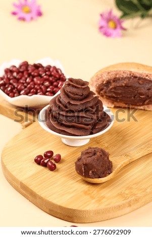 Red bean paste chocolate desserts and pastries displayed on wooden board with fresh flowers and beans