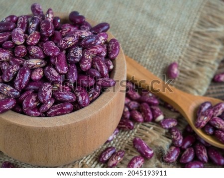 red beans with a pattern. (Delicious variegated, raw common beans) in a wooden bowl on an old wooden table, legumes. Copy space