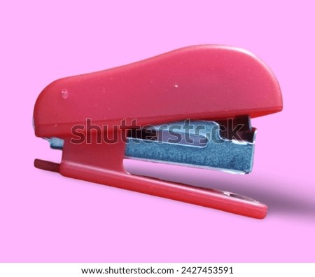 Red beautiful small stapler with pink background. 