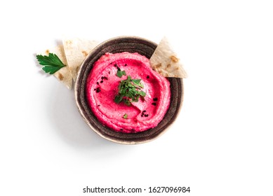 Red Beetroot Hummus bowl, healthy vegan dip. Traditional Middle eastern beet hummus,  spread  with pita bread and vegetables isolated on white. Top view, copy space.