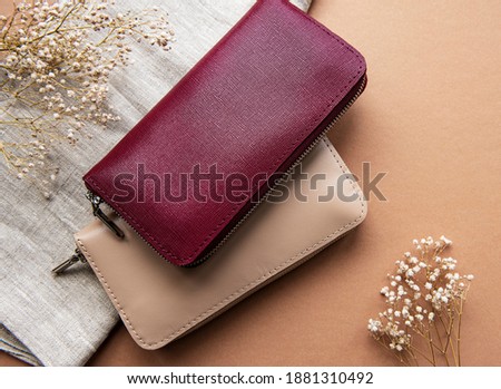 Red and beige leather wallets on brown background