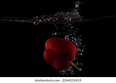 Red bell pepper water splash on black background showing water level. - Powered by Shutterstock