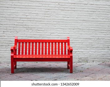 A Red bench and a brick wall - Powered by Shutterstock