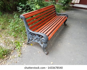 red bench with curved armrests in the yard