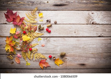 red berriaes and  autumn leaves on old wooden background - Shutterstock ID 1080066509